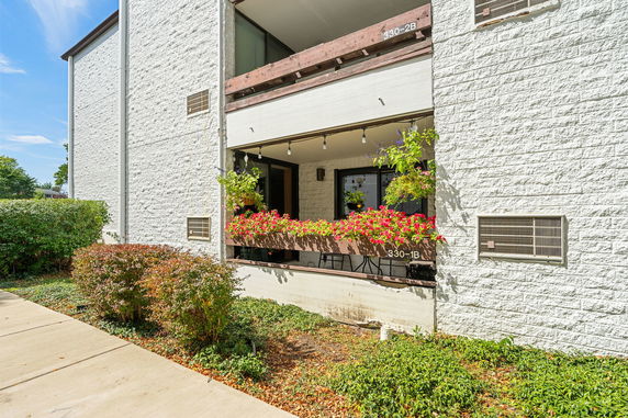 Front view of a two-story building with a balcony and flower decorations.