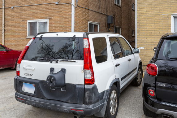 Outdoor parking area next to a brick building with parked cars.