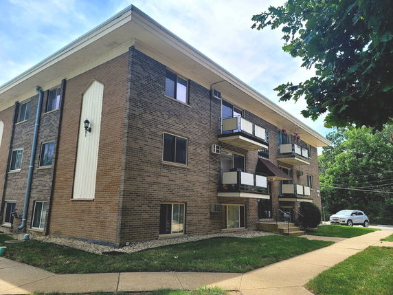 Front view of a multi-story apartment building with balconies.