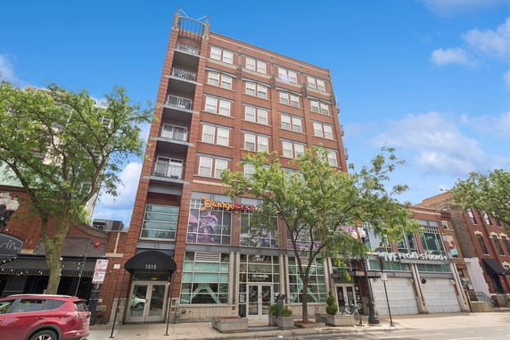 Front view of a multi-story brick building with commercial ground floor.