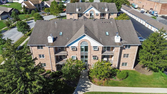 Front view of a multi-story brick apartment building with balconies.