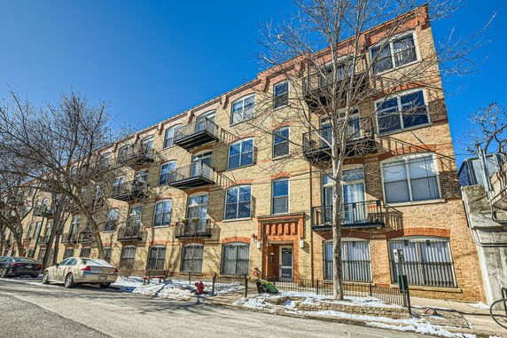 Front view of a multi-story brick building with balconies.