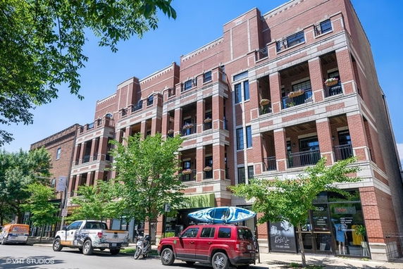 Front view of a multi-story brick building with balconies.