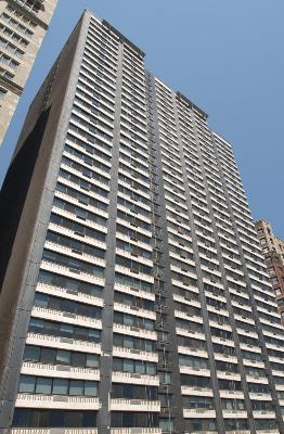 Front view of a tall residential building with multiple balconies.