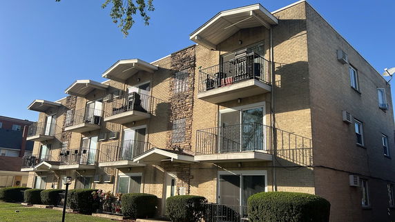 Front view of a multi-story apartment building with balconies.