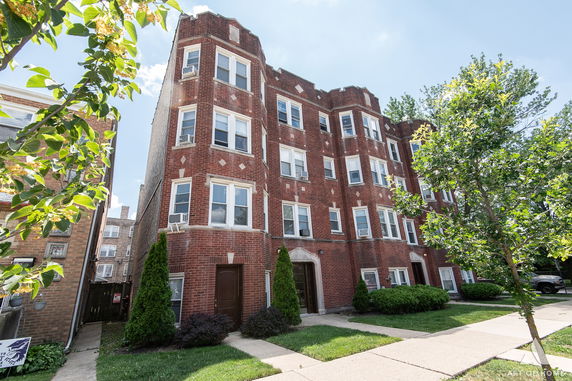 Front view of a multi-story brick apartment building.