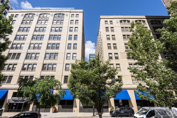 Front view of two adjacent multi-story buildings with beige facades.