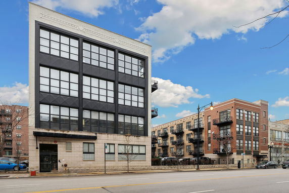 Front view of a multi-story building with large windows.