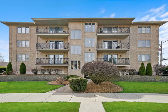 Front view of a multi-story apartment building with balconies.