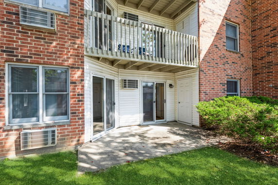 Exterior view of a building with brick walls and sliding glass doors on the ground floor.