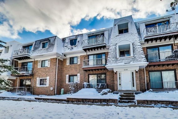 Front view of a multi-story building with balconies and snow-covered exterior.
