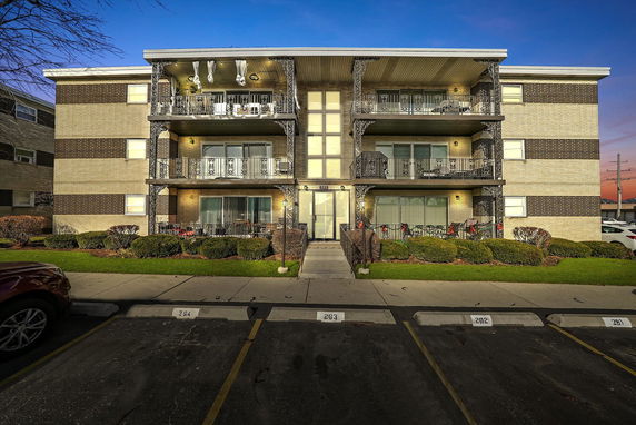 Front view of a multi-story residential building with balconies.