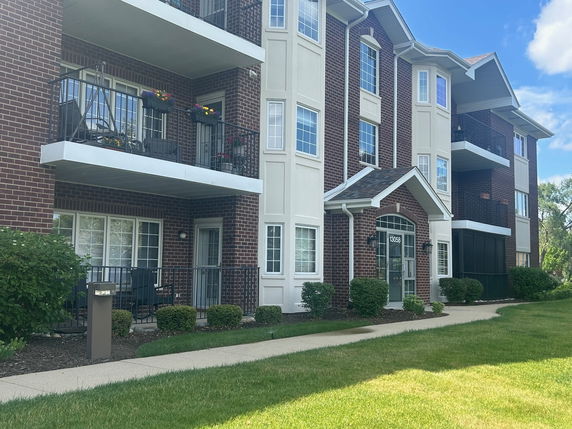 Front view of a multi-story brick building with balconies.