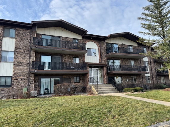 Front view of a multi-story apartment building with balconies.