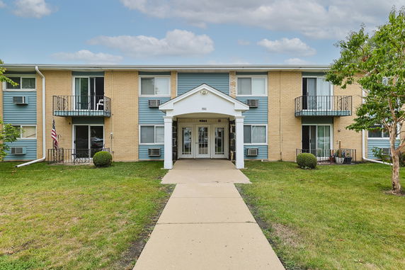 Front view of a two-story apartment building with entrances and balconies.