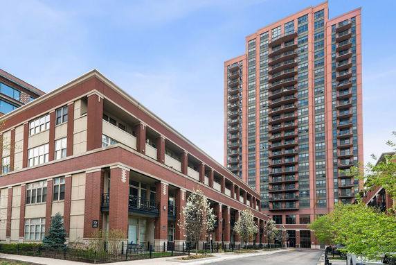 Front view of a multi-story residential building with a high-rise tower and adjacent lower structure.
