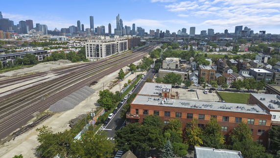 Panoramic view of urban area with railway tracks and city skyline.
