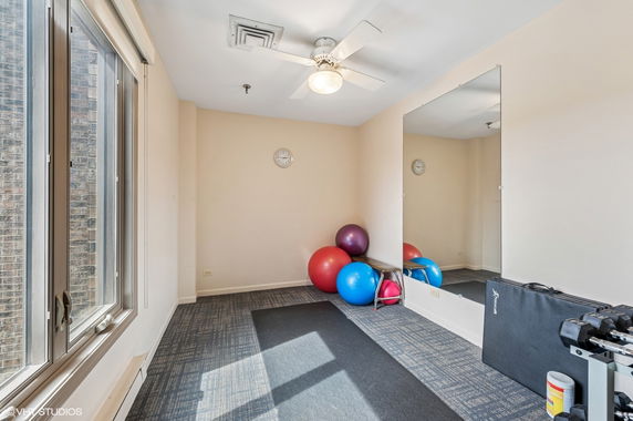 Indoor exercise room with fitness balls, dumbbells, and a large mirror.