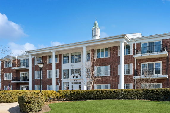 Front view of a multi-story brick building with large white columns.