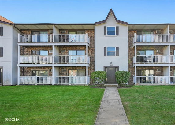 Front view of a multi-story apartment building with multiple balconies.