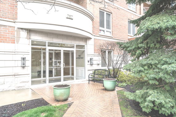 Front view of a building entrance with glass doors and a brick exterior.