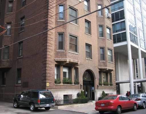 Front view of a multi-story brick building with arched entrance.