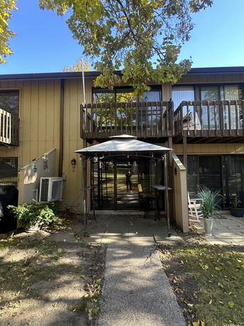 Front view of a two-story building with balconies and a shaded entrance.