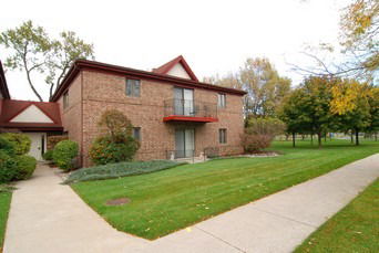 Front view of a two-story brick building with a small balcony.