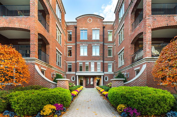 Front view of a brick apartment building with multiple floors and balconies.