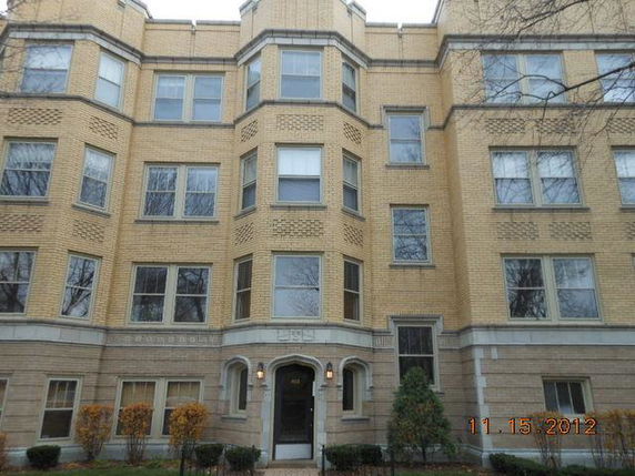Front view of a multi-story brick building with numerous windows.