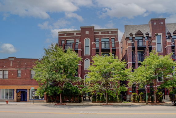 Front view of a multi-story brick building with balconies.