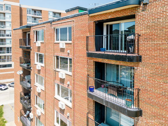 View of a multi-story building with brick facade and balconies.