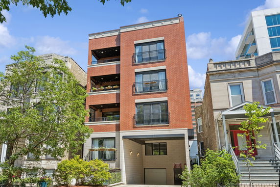 Front view of a multi-story brick building with balconies.