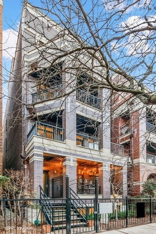 Front view of a multi-story building with balconies and a brick exterior.