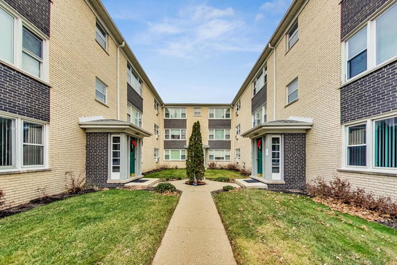 Front view of a multi-story apartment building with symmetrical design.