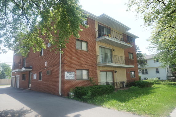 Front view of a three-story brick apartment building.