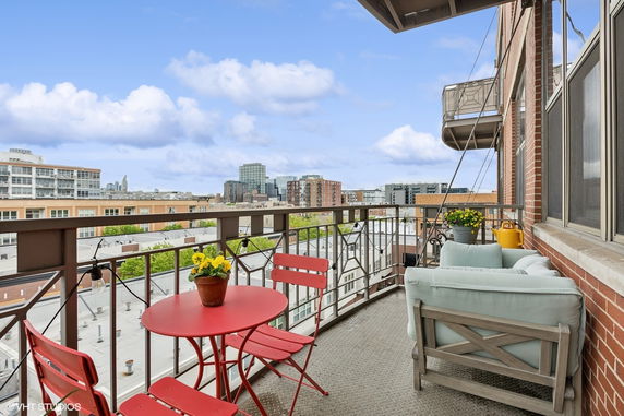 Rooftop balcony with outdoor furniture overlooking cityscape.