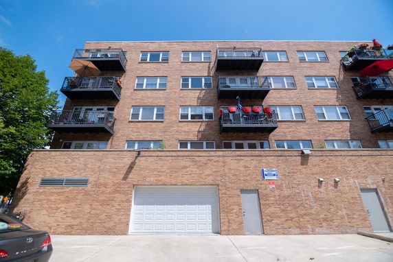 Front view of a multi-story apartment building with balconies.