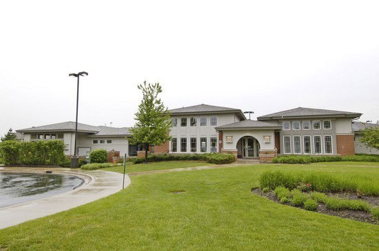 Front view of a two-story building with large windows and an arched entrance.