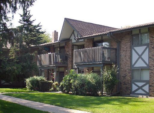 Front view of a multi-story building with balconies and brick facade.