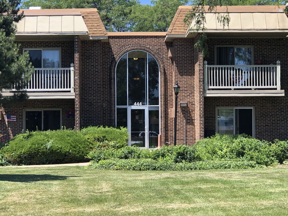Front view of a brick two-story residential building with balconies.