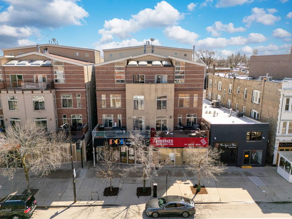 Front view of a multi-story building with commercial spaces on the ground floor.