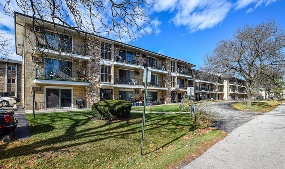 Front view of a three-story apartment building with balconies.