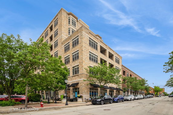 Front view of a multi-story building with a brick exterior and large windows.