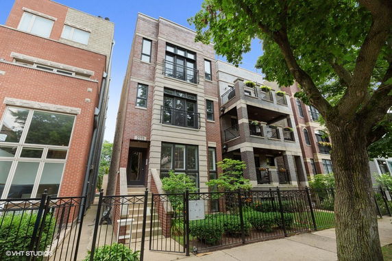 Front view of a multi-story brick building with balconies.