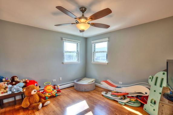 Room with toys, play equipment, and ceiling fan.
