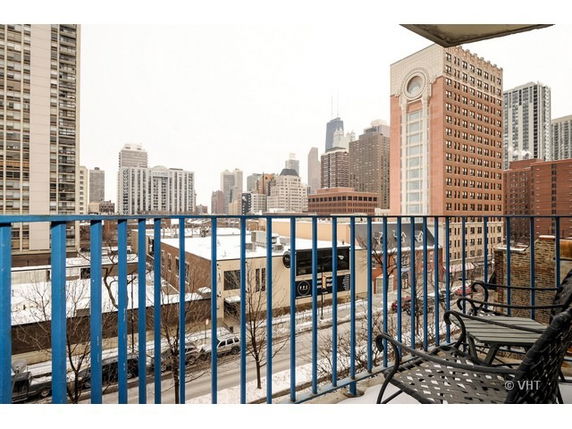 View of surrounding cityscape with multiple high-rise buildings from a balcony.