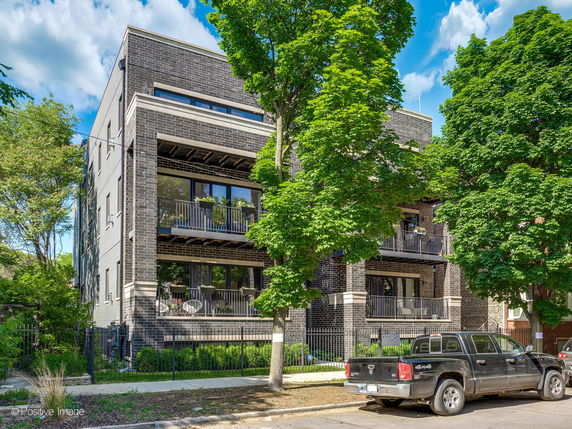 Front view of a modern multi-story brick building with balconies.