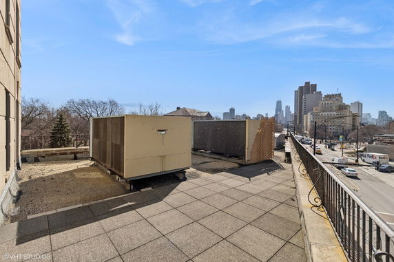 Rooftop with air conditioning units and a distant city skyline view.