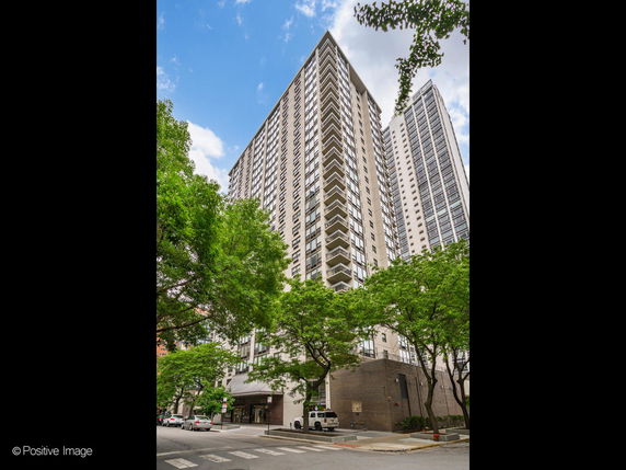 Front view of a tall residential building with multiple floors and balconies.